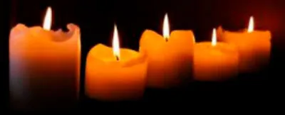 Cinco velas encendidas sobre fondo oscuro