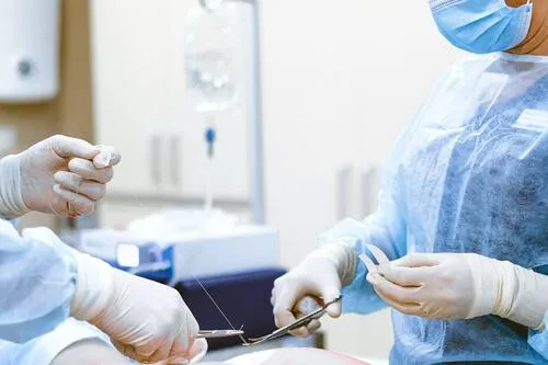 Equipo médico con guantes y mascarillas realizando una cirugía