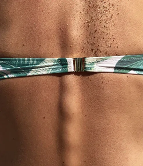 Espalda de una mujer con la parte de arriba de un bikini de hojas verdes