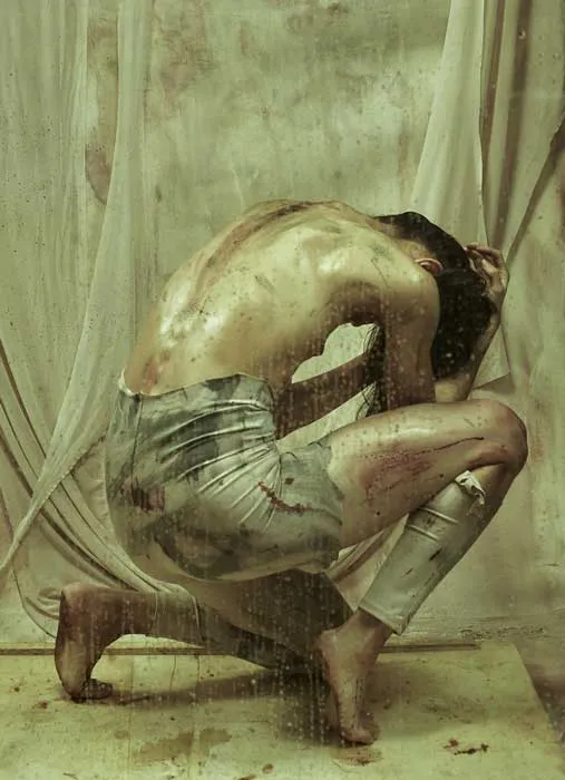 Bailarina encogida sobre sí misma, agachada, con la espalda curvada, en una foto-performance de danza contemporánea