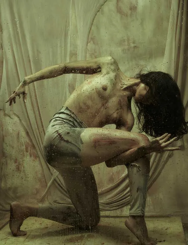 Bailarina con una rodilla en el suelo y un brazo extendido hacia un lado, en una foto-performance de danza contemporánea