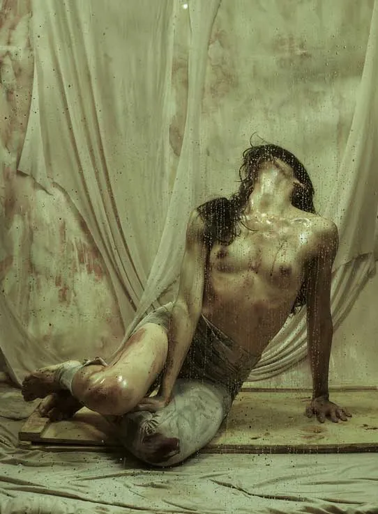 Bailarina sentada en el suelo con el rostro cubierto por el cabello, en una foto-performance de danza contemporánea