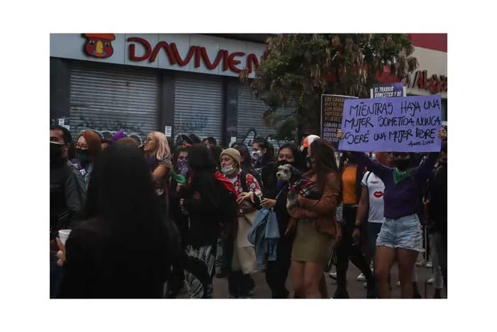 Mujeres marchan con un cartel morado durante la huelga feminista del 8 de marzo de 2021 en Bogotá