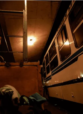 Interior de una terminal con un bus antiguo estacionado bajo una luz cálida
