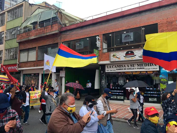 Manifestantes con banderas de Colombia en una calle comercial de Bogotá durante el Paro Nacional