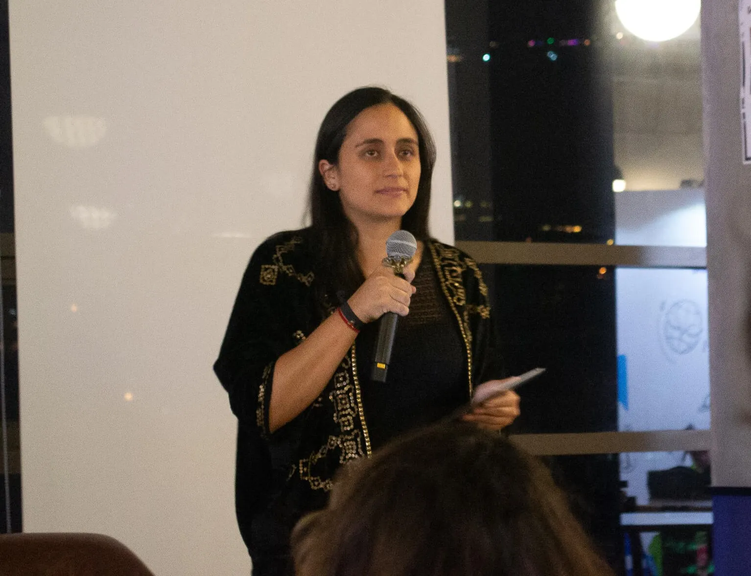 María Mónica Zapata habla con micrófono sobre su artículo de trabajadoras sexuales venezolanas en Colombia
