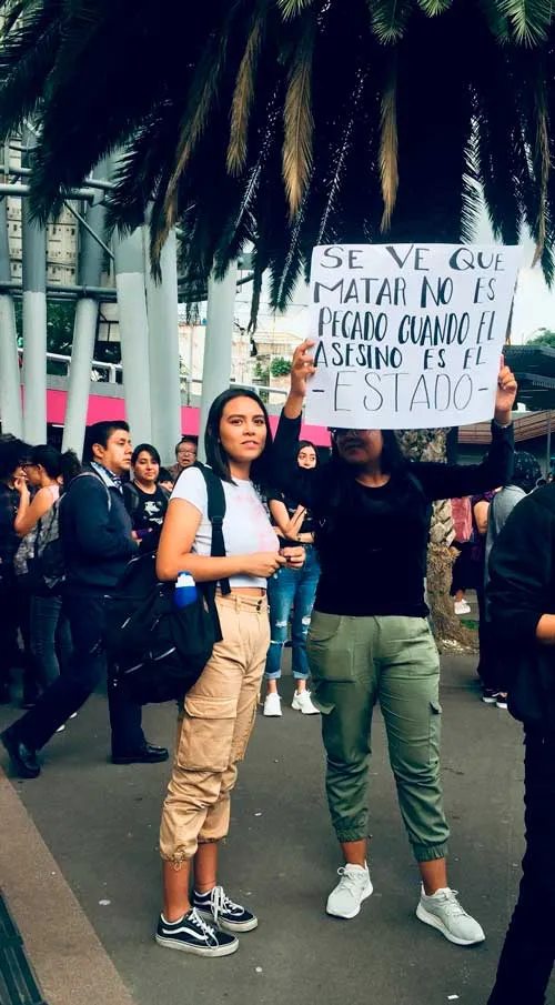 Mujer sostiene un cartel en alto entre manifestantes en una protesta en Ciudad de México