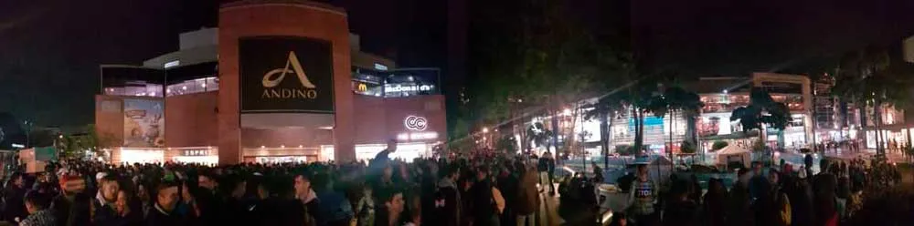 Vista panorámica nocturna de una multitud frente al Centro Comercial Andino durante el besatón