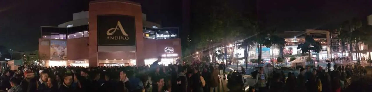 Vista panorámica nocturna de una multitud frente al Centro Comercial Andino durante el besatón