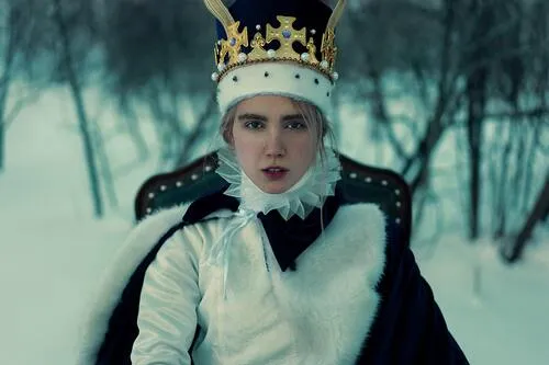 Persona con corona, cuello de gola y capa de piel blanca sentada en un trono en un bosque nevado