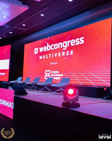 Escenario del «WebCongress Multiverse» con pantalla roja y foco rojo, foto de Revista Level