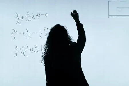Silueta de una docente que escribe con el brazo en alto en una pizarra blanca con ecuaciones